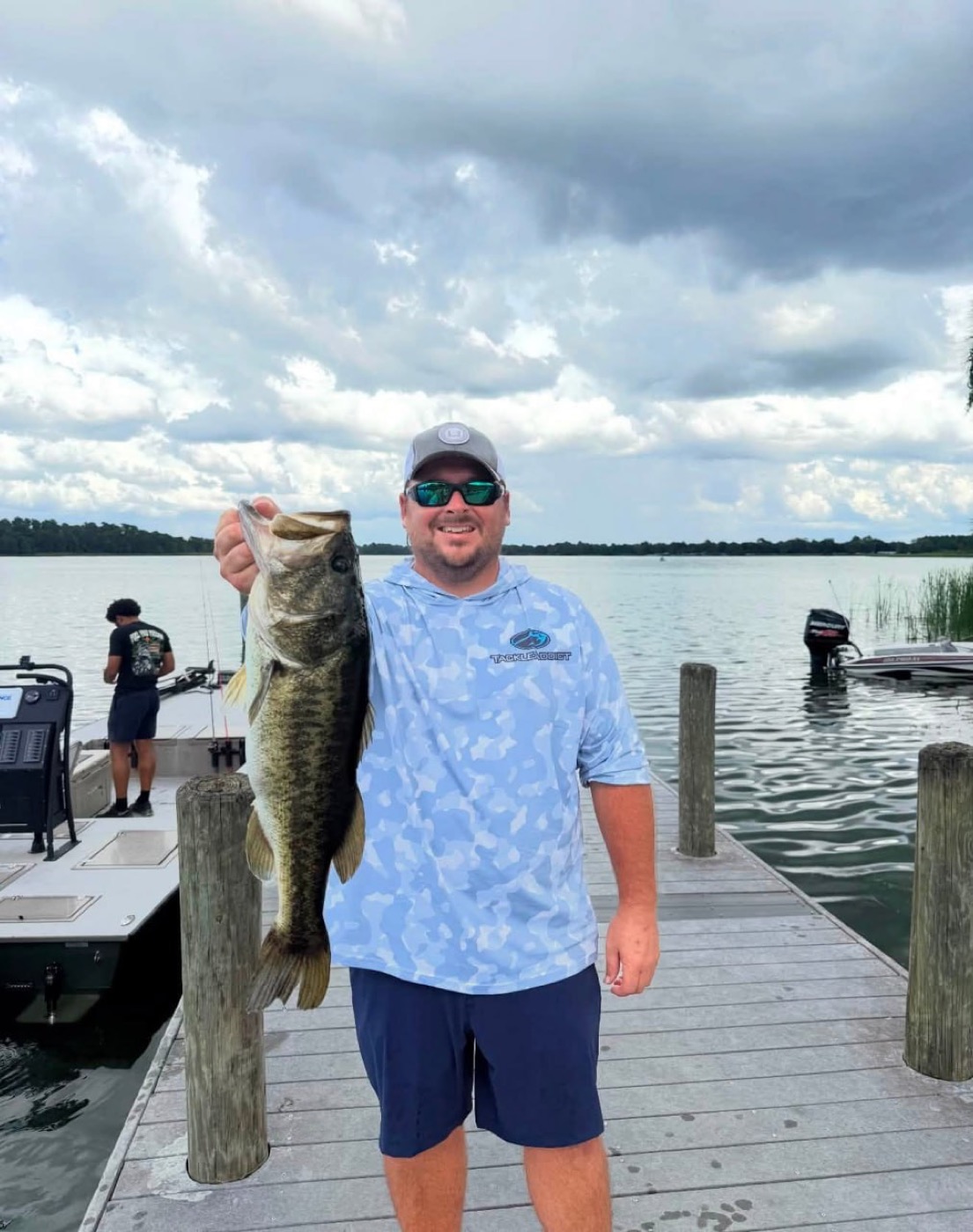Angler holding a largemouth bass on a dock
