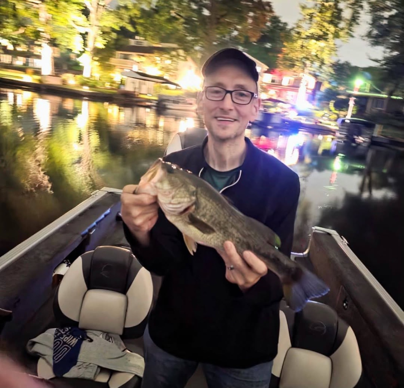 Angler holding a bass from a fishing boat